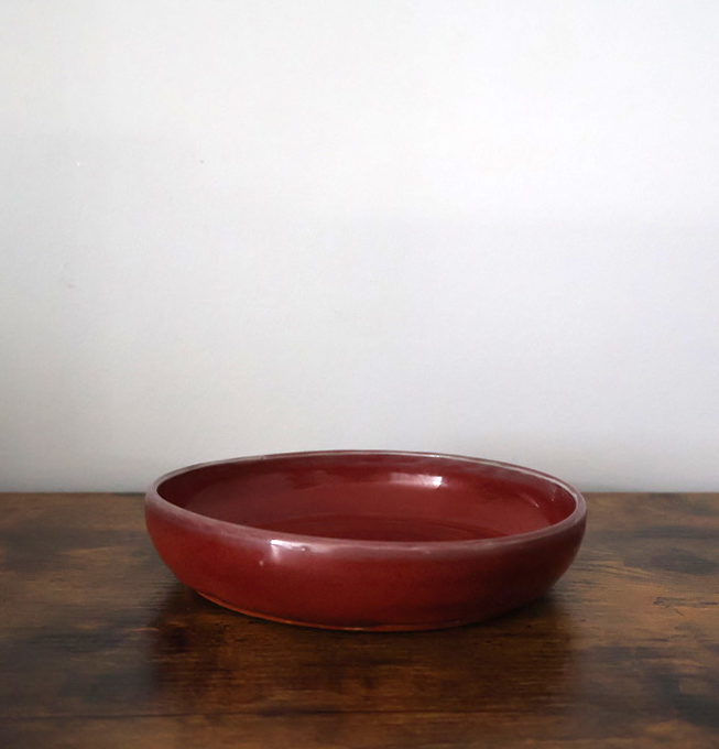 Shallow oxblood red glazed ceramic dish