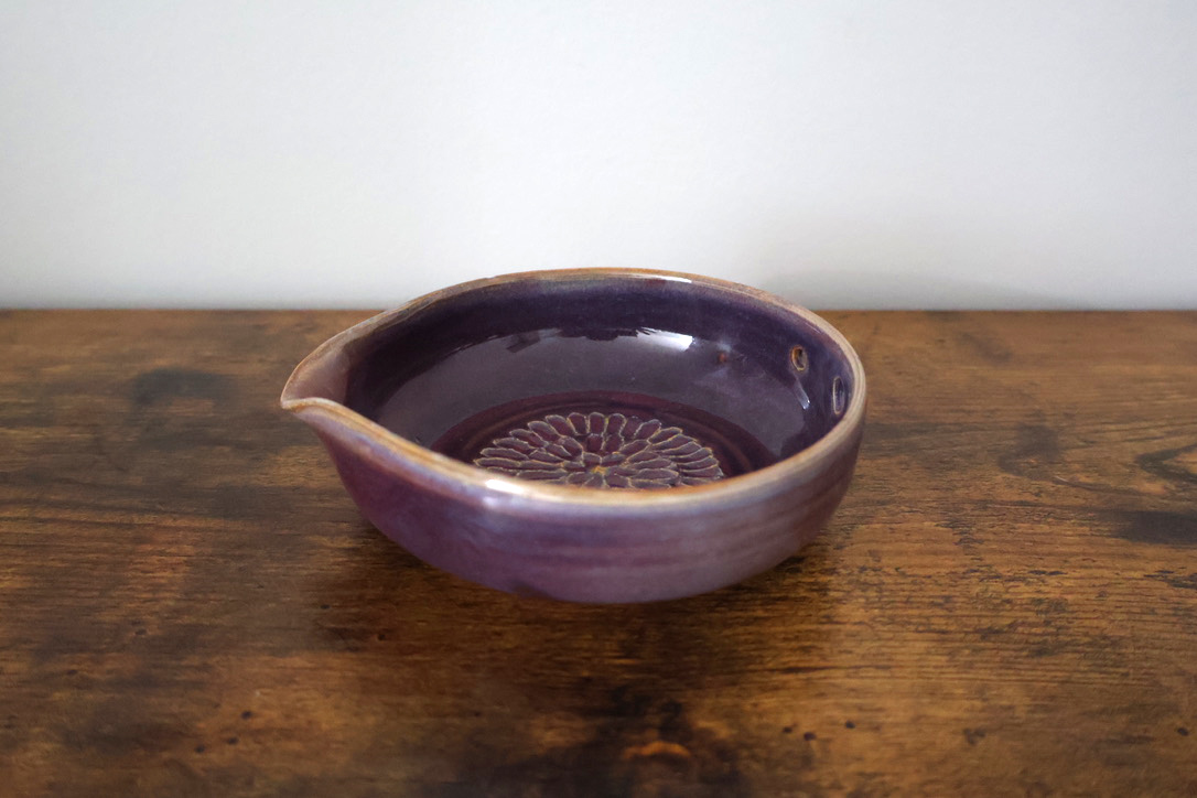 Purple glazed pouring bowl with carved floral center