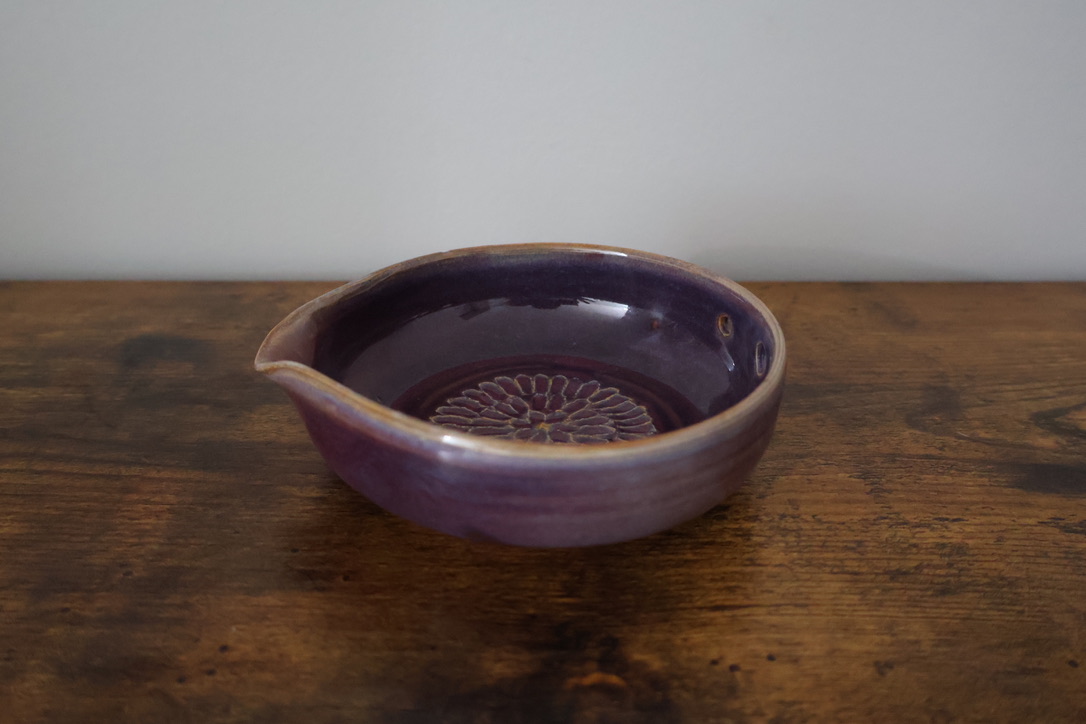 Purple glazed pouring bowl with carved floral center